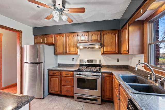 kitchen with appliances with stainless steel finishes, sink, ceiling fan, and light tile patterned floors