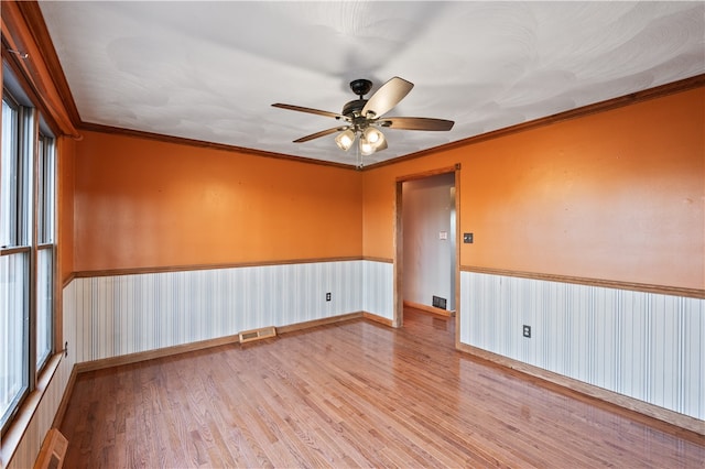 empty room with light hardwood / wood-style floors, ceiling fan, and crown molding