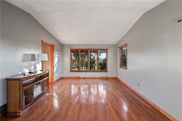 unfurnished living room with light wood-type flooring and lofted ceiling