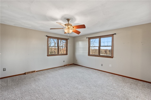 unfurnished room featuring ceiling fan, a healthy amount of sunlight, and carpet flooring