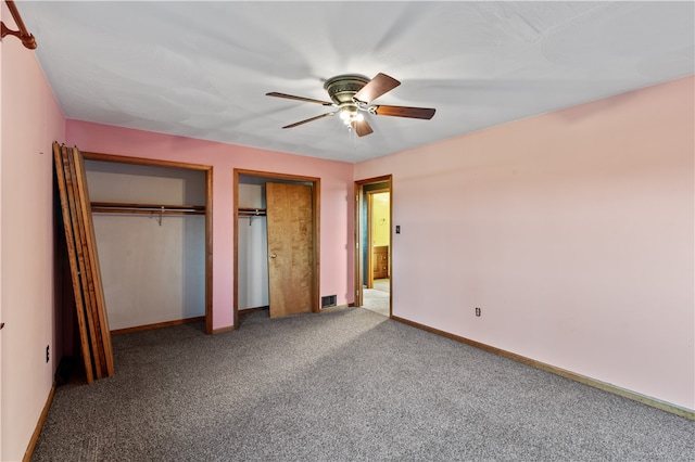 unfurnished bedroom featuring multiple closets, ceiling fan, and carpet floors