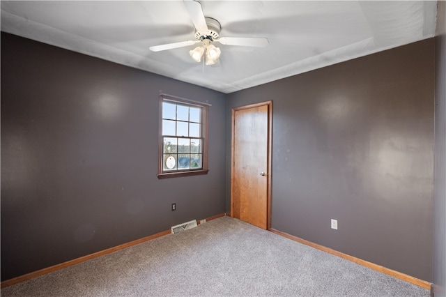 carpeted spare room featuring ceiling fan