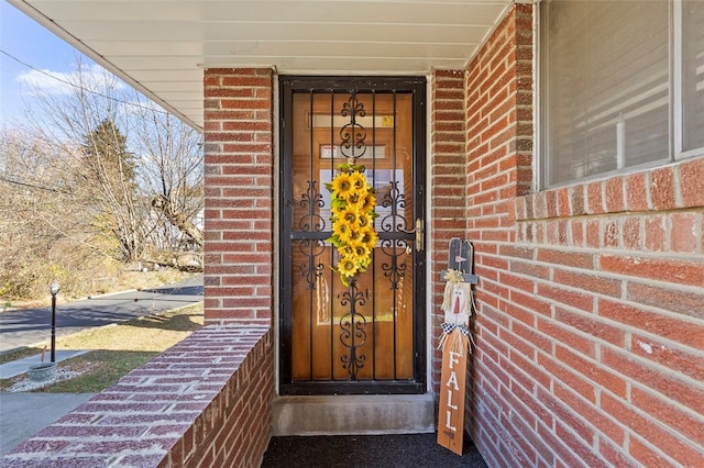 doorway to property featuring brick siding