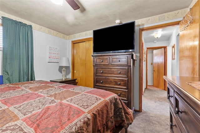 bedroom with light carpet, a closet, and a ceiling fan