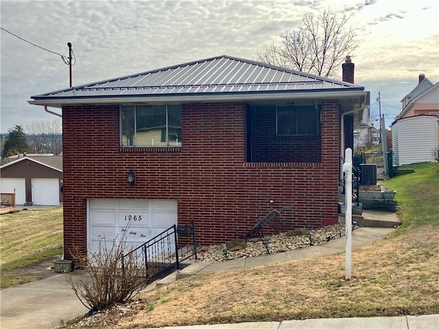 view of front of property featuring concrete driveway, brick siding, metal roof, and a chimney