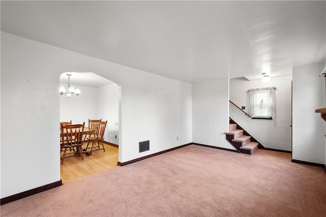 carpeted living room featuring an inviting chandelier