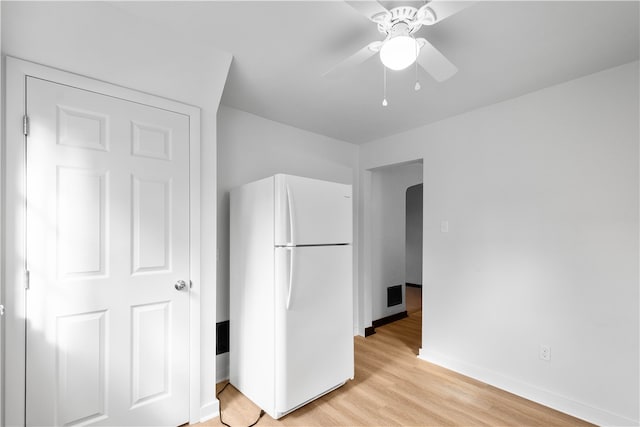 unfurnished bedroom with ceiling fan, white refrigerator, and light hardwood / wood-style floors