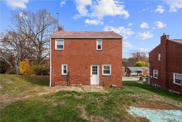 back of property featuring a lawn