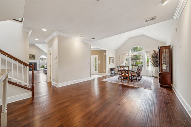 dining space featuring dark hardwood / wood-style flooring, a chandelier, crown molding, and vaulted ceiling