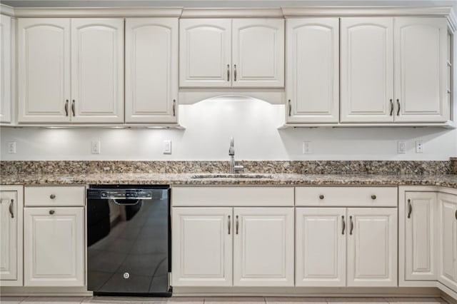 kitchen featuring black dishwasher, white cabinets, light tile patterned floors, sink, and stone counters