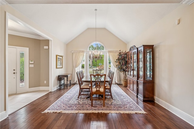 dining space with a chandelier, lofted ceiling, and wood-type flooring