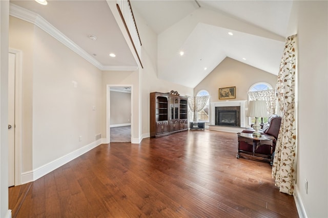 living room with high vaulted ceiling, hardwood / wood-style floors, and crown molding