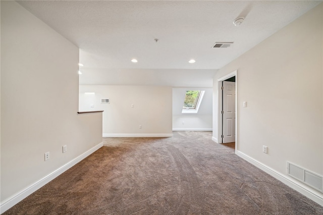 unfurnished room featuring carpet flooring and a skylight