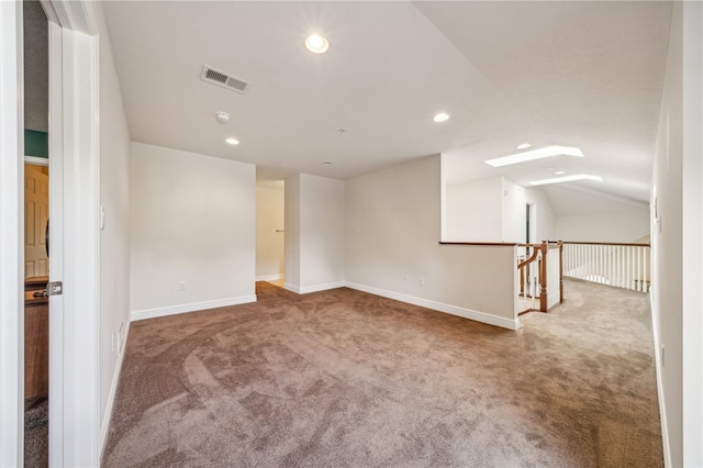 carpeted empty room featuring vaulted ceiling