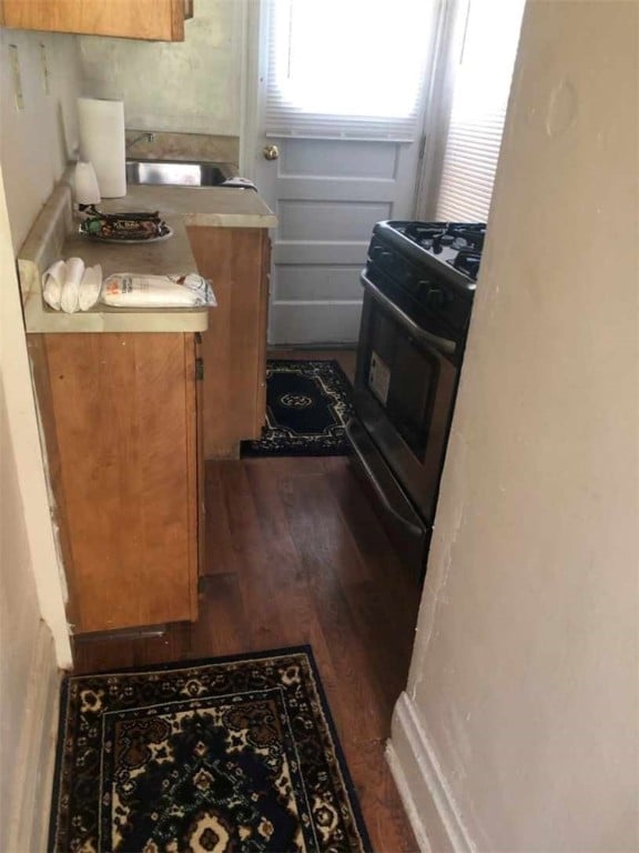 kitchen featuring black range with gas stovetop, sink, and dark hardwood / wood-style flooring