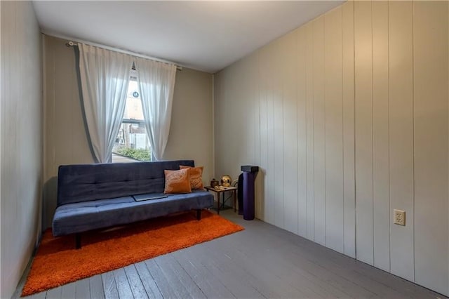 sitting room featuring hardwood / wood-style floors and wooden walls