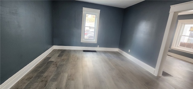 unfurnished room featuring hardwood / wood-style flooring and plenty of natural light