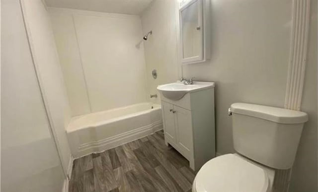 full bathroom featuring toilet, vanity, hardwood / wood-style floors, and bathing tub / shower combination