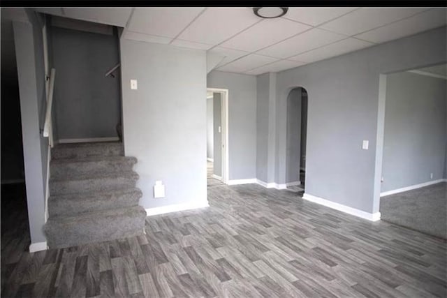 interior space with a paneled ceiling and hardwood / wood-style floors