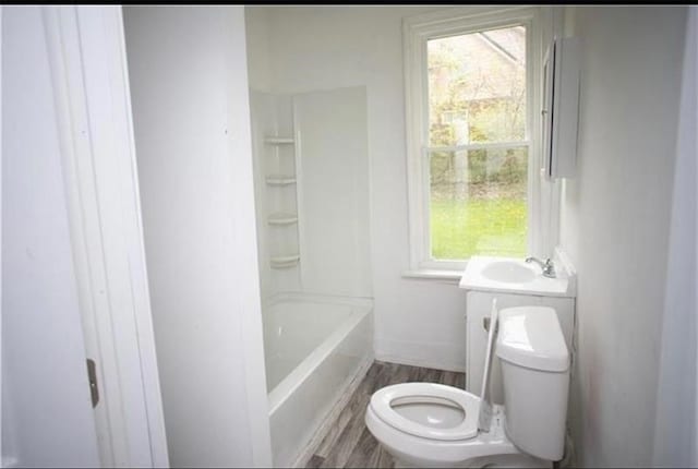 full bathroom with toilet, vanity, a wealth of natural light, and hardwood / wood-style flooring