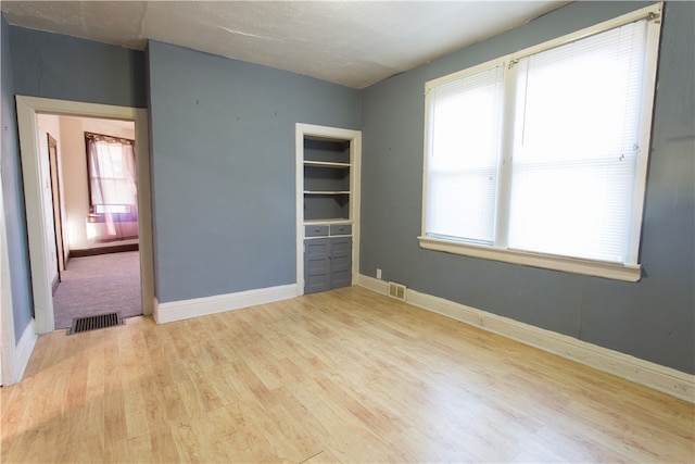 empty room with light hardwood / wood-style flooring