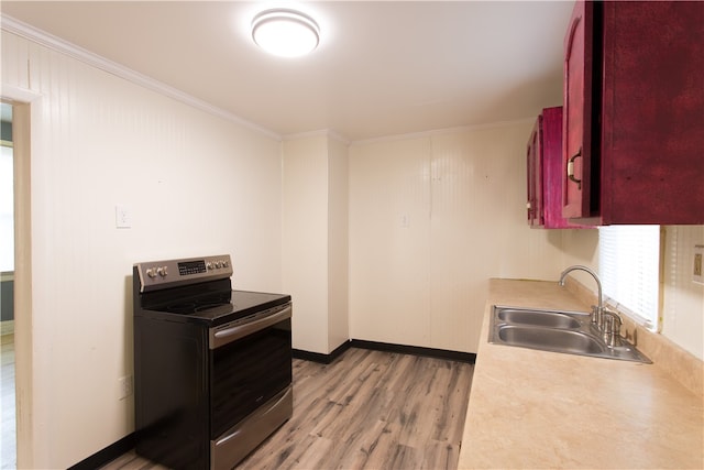 kitchen featuring light hardwood / wood-style flooring, electric stove, sink, and crown molding