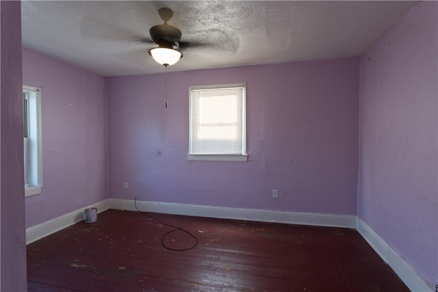 unfurnished room with dark wood-type flooring, a textured ceiling, and ceiling fan