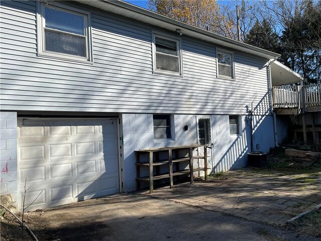 back of house featuring a garage and a wooden deck