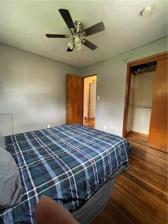 bedroom with ceiling fan, dark hardwood / wood-style floors, and a closet