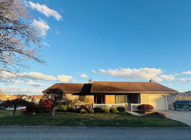 single story home with a garage, a front lawn, and covered porch