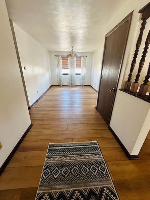 corridor with a chandelier and light hardwood / wood-style flooring