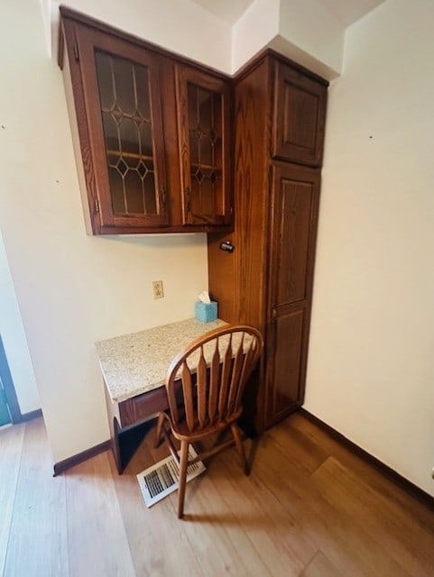 dining area featuring built in desk and light hardwood / wood-style floors