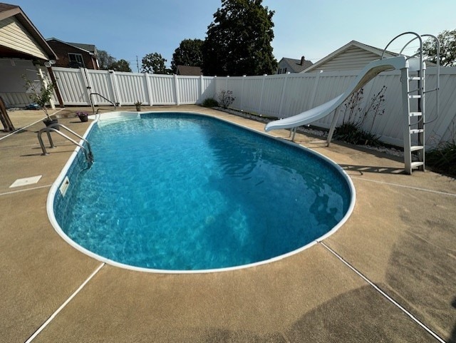 view of swimming pool with a patio and a water slide