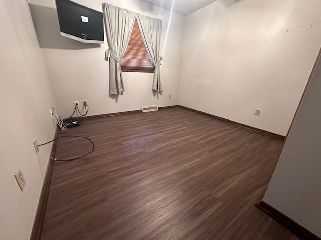 spare room featuring dark wood-type flooring