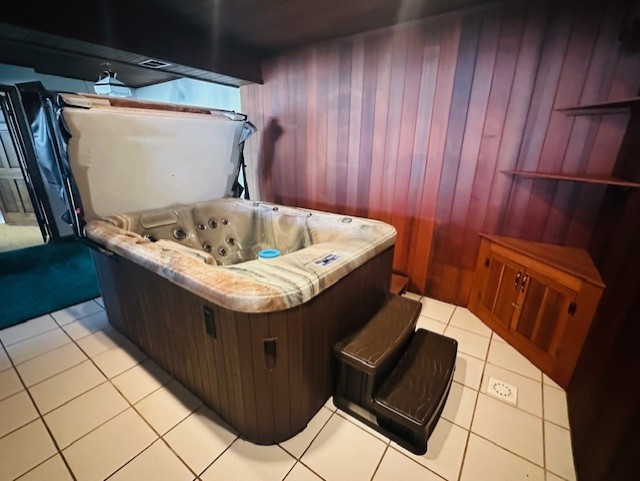 miscellaneous room with wood walls and light tile patterned floors