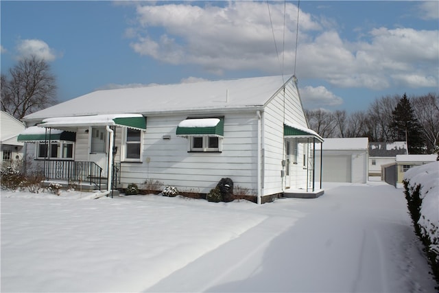 view of front facade featuring a porch, an outdoor structure, and a garage