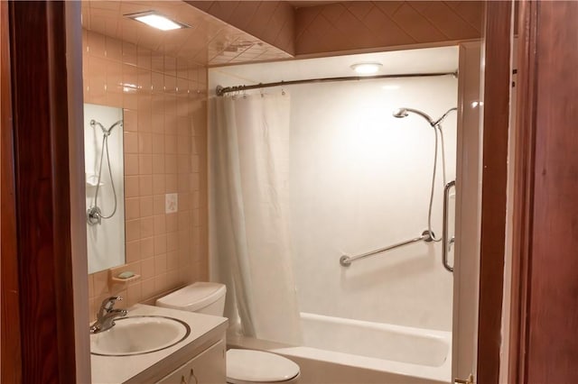 full bathroom featuring shower / tub combo, vanity, toilet, and tile walls