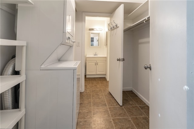 laundry room featuring stacked washing maching and dryer and sink