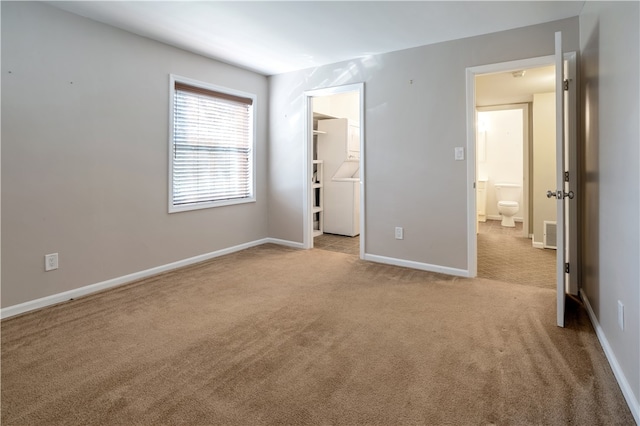 unfurnished bedroom featuring a spacious closet, light colored carpet, and a closet