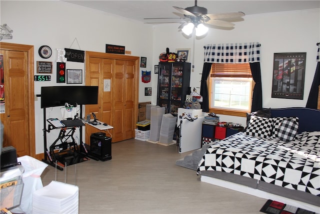 bedroom featuring hardwood / wood-style flooring, ceiling fan, crown molding, and a closet