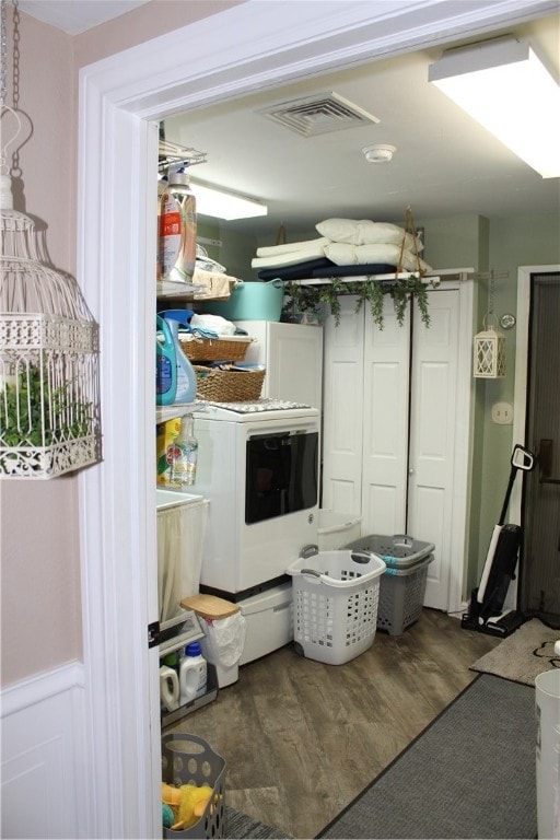 washroom featuring cabinets, hardwood / wood-style flooring, and washer / dryer