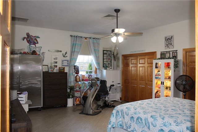 bedroom featuring dark hardwood / wood-style flooring, ceiling fan, and a closet