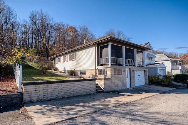 view of front of home with a garage and a sunroom