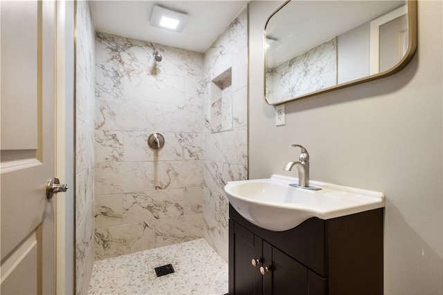 bathroom with vanity and a tile shower