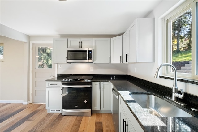 kitchen featuring white cabinets, appliances with stainless steel finishes, sink, and plenty of natural light