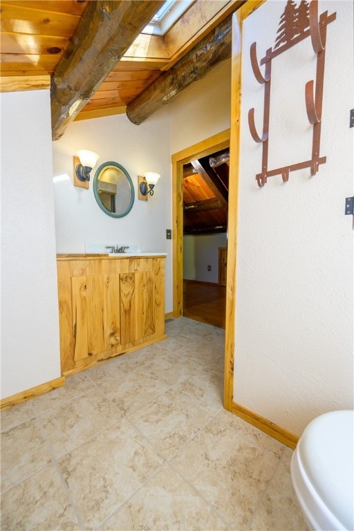 bathroom with vanity, lofted ceiling with skylight, and wood ceiling