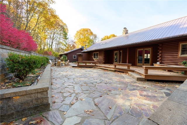 rear view of property featuring a deck and a patio area