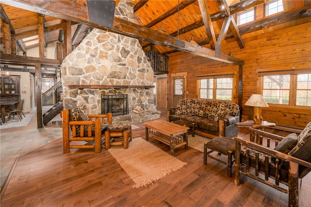 living room featuring high vaulted ceiling, wooden walls, and wooden ceiling