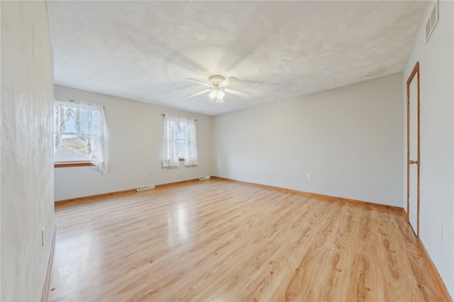 empty room with ceiling fan and light hardwood / wood-style floors