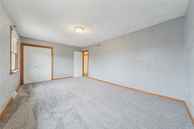 unfurnished bedroom with carpet flooring and a closet